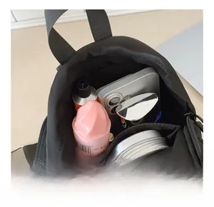 Internal capacity view of black nylon backpack showing main compartment and front zipper pocket