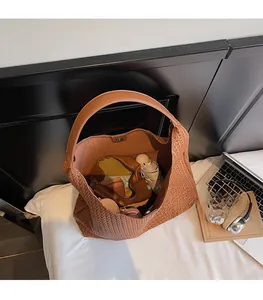 Top view of spacious brown woven tote bag interior holding daily essentials and accessories
