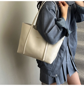 Dettaglio della borsa tote in pelle color crema con finitura testurizzata e scritte moda