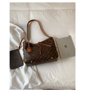 Detailansicht der braunen Tragetasche mit Comic-Muster und passender Mini-Tasche