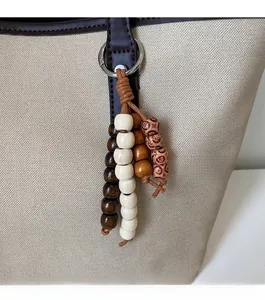 Close-up of vintage multi-color wooden bead pendant on deep brown leather strap