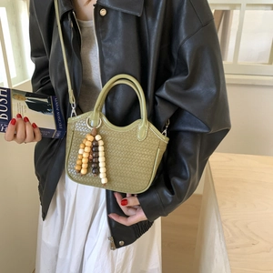 Green woven bucket bag for women featuring wooden beads and a sleek crossbody strap