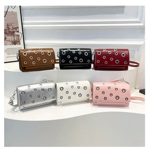Six stylish baguette bags in various colors featuring metal eyelet rivets on display