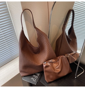 Detail of dark brown woven tote bag and matching clutch with mirror reflection