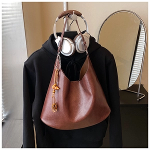 Brown vintage shoulder bag with wooden bead tassel detail and textured faux leather finish