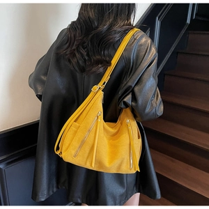 Detail of yellow suede tote bag with multiple zip pockets and adjustable shoulder strap