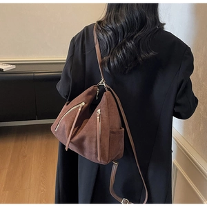 Brown faux suede mini backpack and crossbody bag with metal zippers shown on a model