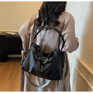 Close-up of black lychee grain leather tote bag with stylish buckle and strap detail