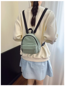 Rear view of a mint green mini nylon backpack showing adjustable straps and daily wear size