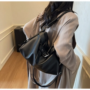 Detail view of large black litchi grain leather tote bag with silver buckle strap