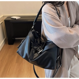 Close-up of black lychee grain leather tote bag featuring silver buckle and adjustable strap