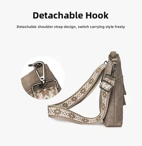 Detail view of a retro brown canvas crossbody bag with a wide ethnic strap and silver hook
