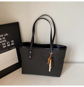 Detail view of the reinforced rivets and textured fabric on the large tote bag with beads
