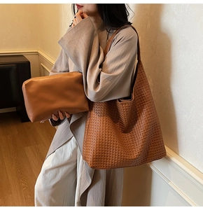 Detailed close-up of brown woven texture tote bag with matching leather clutch set