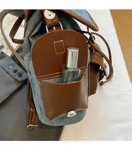 Close-up of denim backpack side pocket with magnetic buckle showing storage capacity