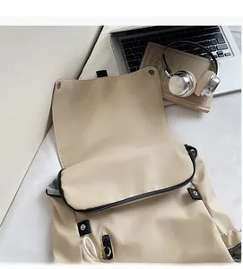 Detail of beige nylon backpack with functional pockets, laptop and headphones on white background