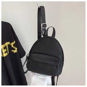 Detail showing adjustable strap with silver metal buckle on black nylon mini backpack