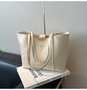 Dettaglio della borsa tote off-white con doppi manici e chiusura magnetica dorata
