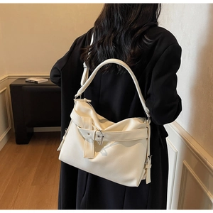 Detailed texture of off-white lychee grain leather tote bag with silver buckle details