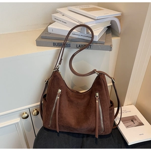 Detail view of large vintage brown hobo bag with decorative zippers and adjustable straps