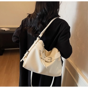 Macro detail of creamy white lychee grain leather tote bag with side buckle decoration