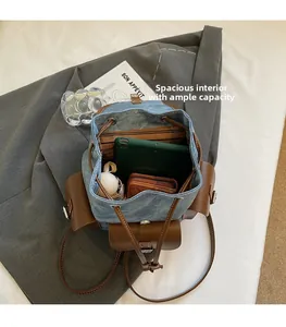 Detail view of denim backpack showing striped lining and large interior storage space