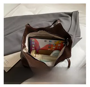 Spacious interior of dark brown tote bag showing fabric lining and zipper pocket