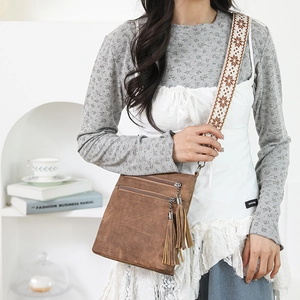Detail of vintage brown crossbody bag with retro fringe zippers and ethnic wide strap