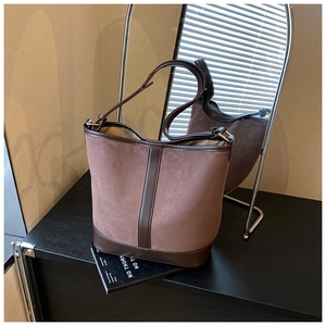 Detail of vintage bucket bag featuring brown suede stitching and adjustable shoulder strap
