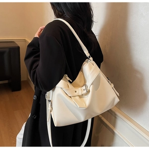 Detail of off-white lychee leather tote bag with metal buckle and adjustable strap