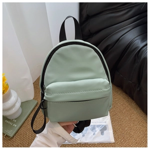 Detail showing mint green mini PU leather backpack with front zipper pocket and strap