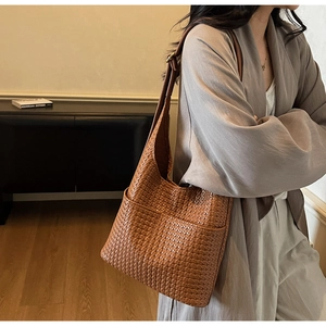 Détail du sac hobo en cuir tressé caramel avec bandoulière réglable et texture riche