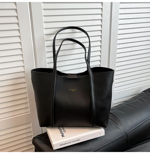 Dettaglio macro della borsa tote in pelle nera di alta qualità con logo dorato elegante