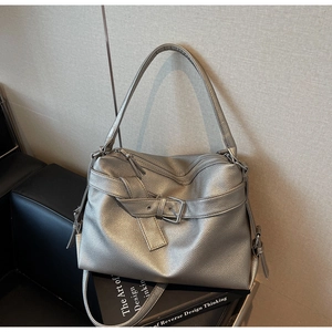 Detail view of silver lychee texture leather tote bag with metallic coating and buckles
