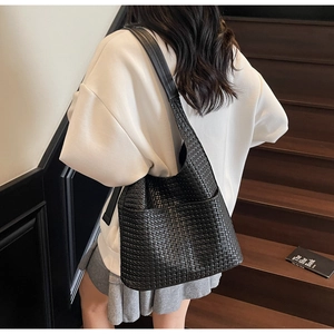 Détail du sac à bandoulière tressé noir montrant la texture Intrecciato pour femme