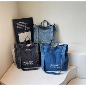 Detailed view of denim tote bags in black, dark blue, and light blue with shoulder straps