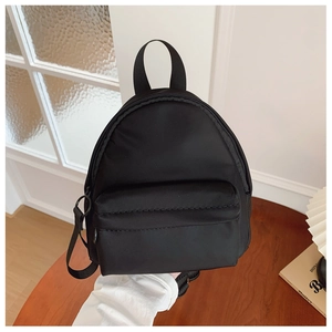Close-up of lightweight black mini nylon backpack with zippered front pocket