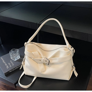 Detail of creamy white tote bag with lychee grain texture and metal buckle belt