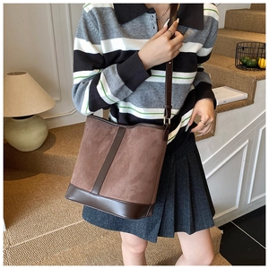 Detail of vintage matte suede bucket bag with adjustable leather strap and textured finish