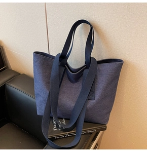 Detail of a navy canvas tote bag with reinforced stitching and wide shoulder straps