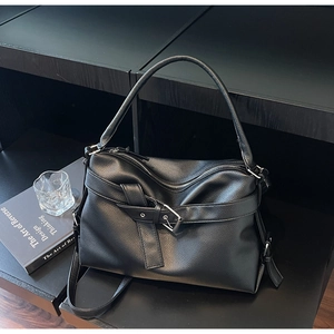 Detail of black pebbled leather tote bag with silver buckle and minimalist belt decoration