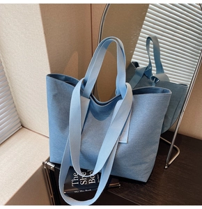 Detail view of light blue canvas tote bag showing heavy denim texture on wooden surface