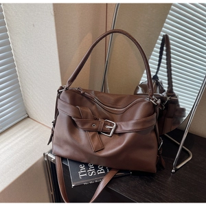 Detailed macro view of dark brown tote bag showing lychee grain texture and zipper closure