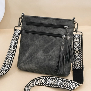 Gray vintage crossbody bag with fringe details and a bohemian embroidered wide strap