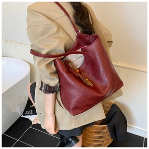 Deep red oil-wax leather tote bag detail with wooden bead tassel and spacious interior