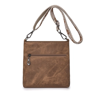 Detailed macro view of the vintage brown canvas bag with ethnic woven shoulder strap