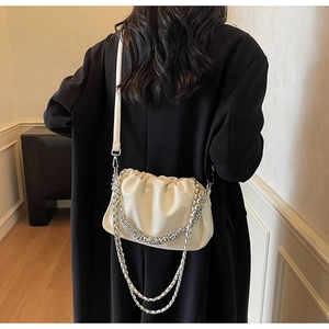 Detail of white pleated cloud bag with chunky silver chain and leather strap