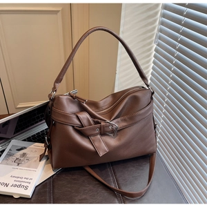 Close-up of deep brown lychee grain leather tote bag with elegant buckle and strap details