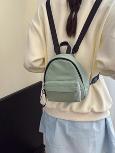 Mint green nylon mini backpack for women with black contrast zippers and adjustable straps