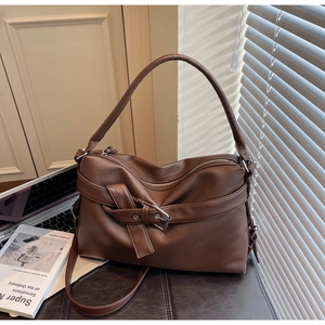 Close-up of deep brown lychee grain leather tote bag with silver buckle details